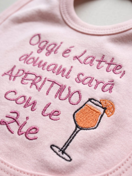 Dettaglio del ricamo sulla bavetta rosa con coppa e arancia