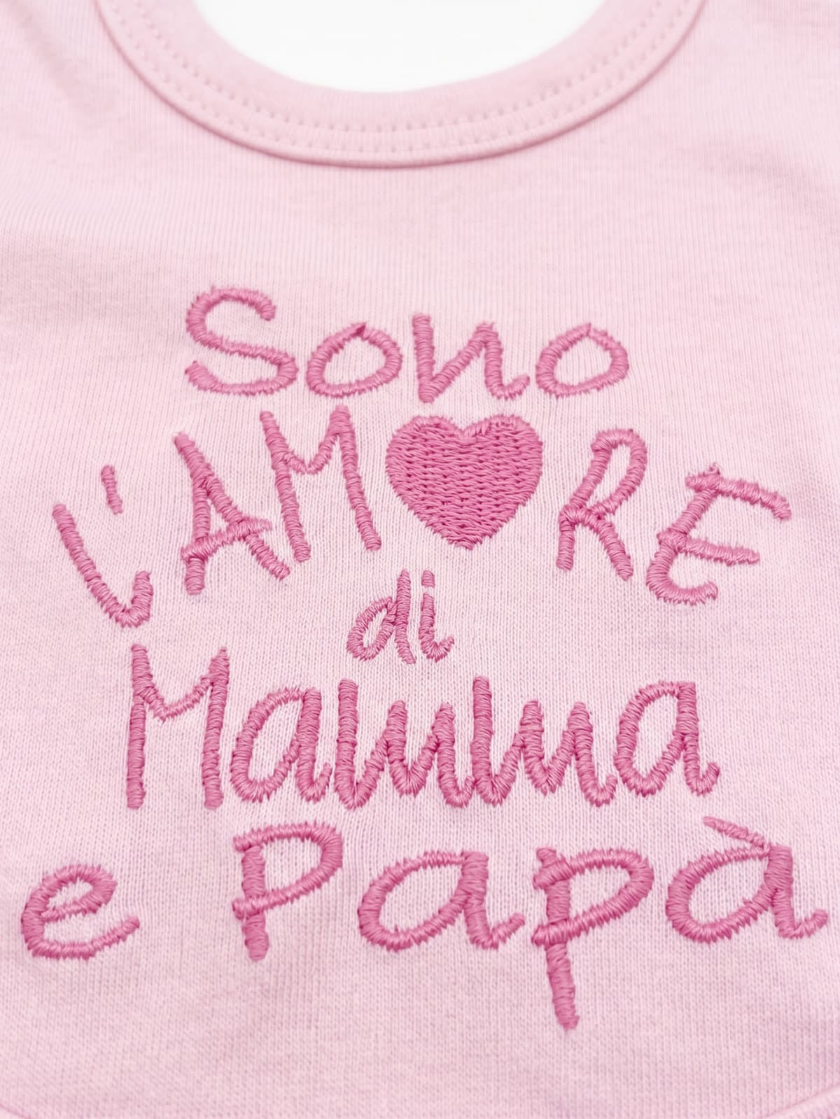 Bavetta rosa ricamata con la frase Sono l’amore di mamma e papà e un cuore