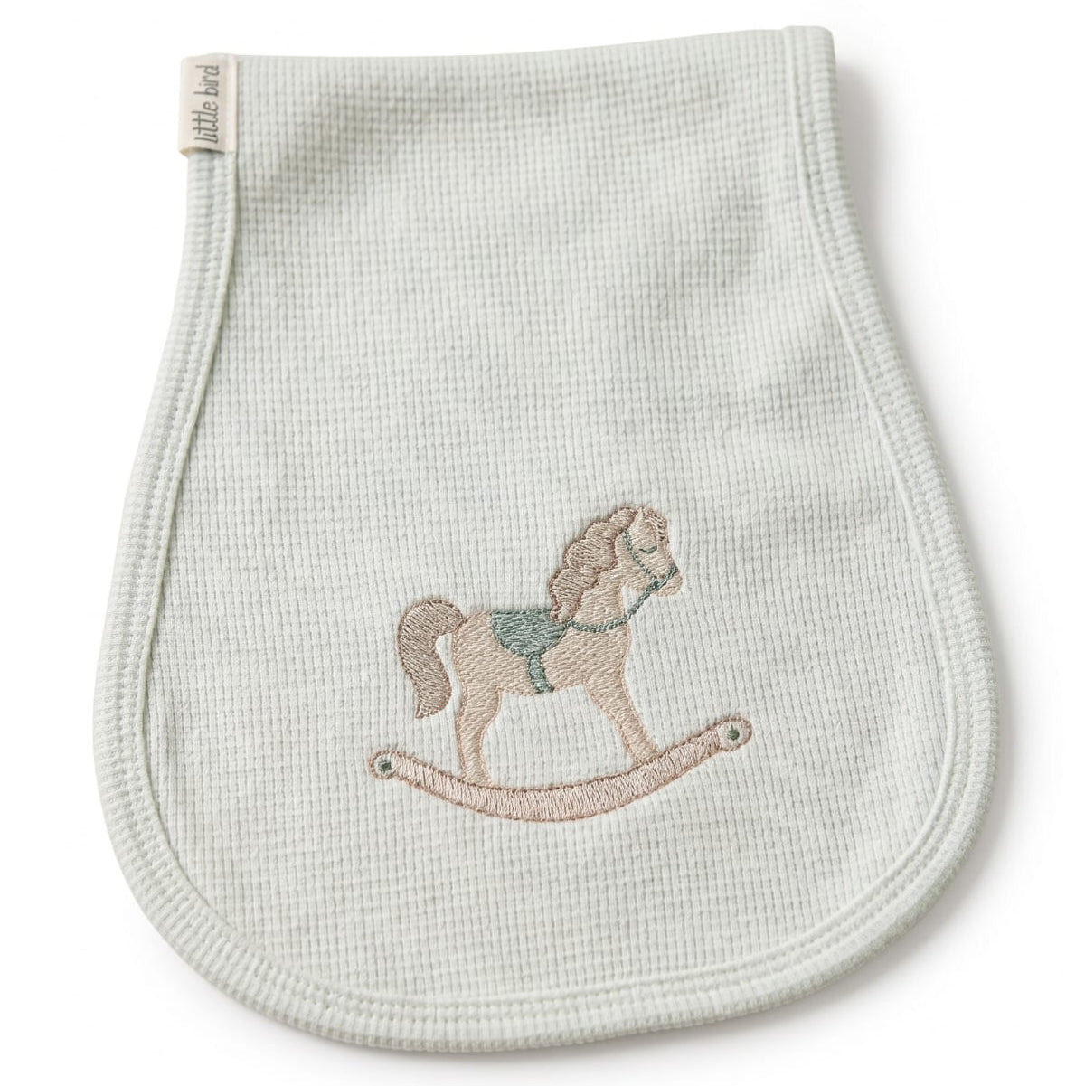 Primo piano del ricamo cavalluccio a dondolo beige e verde