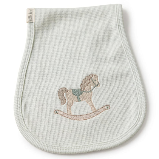 Primo piano del ricamo cavalluccio a dondolo beige e verde