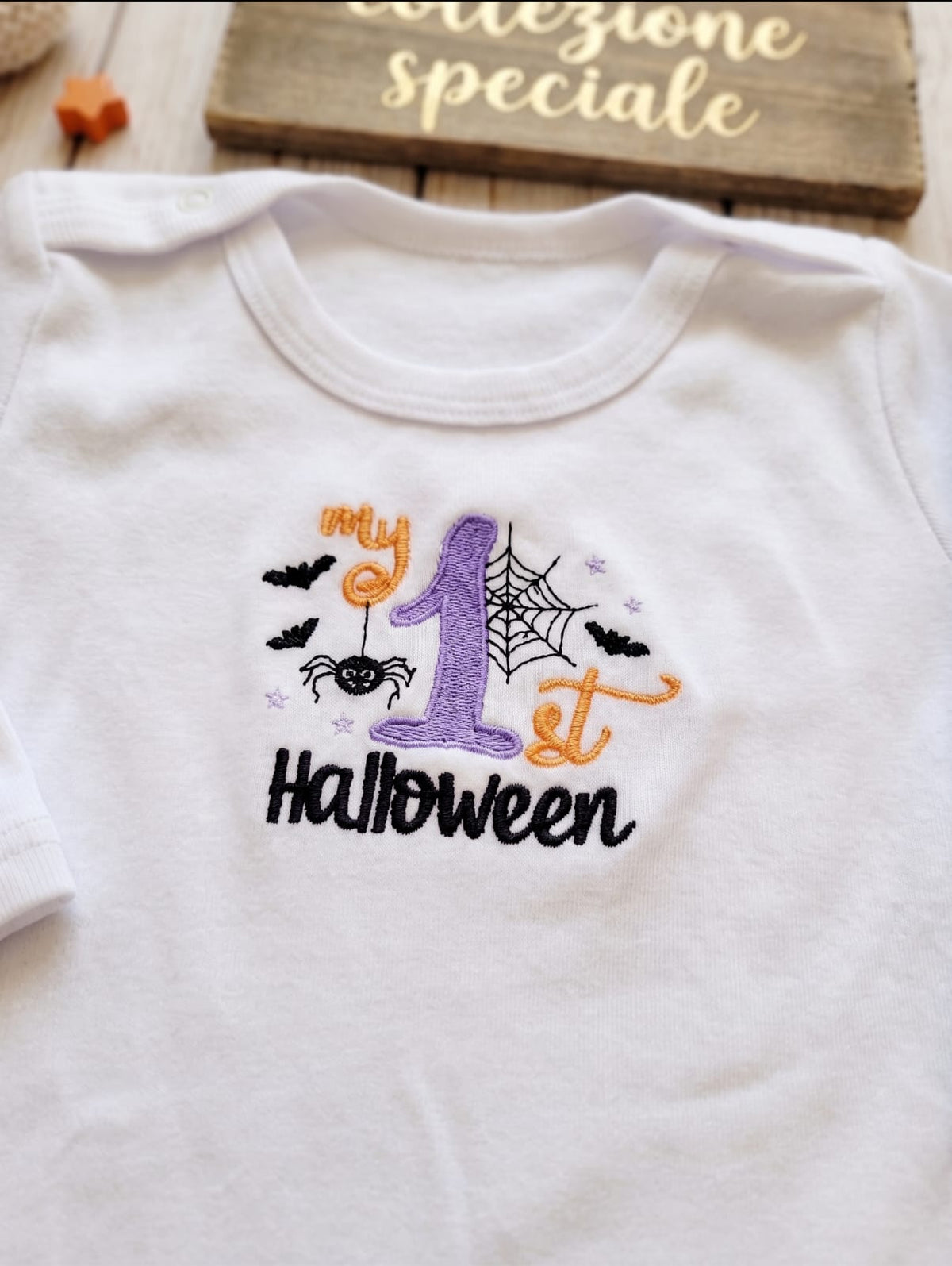 Dettaglio ricamo My 1st Halloween su body bianco neonato