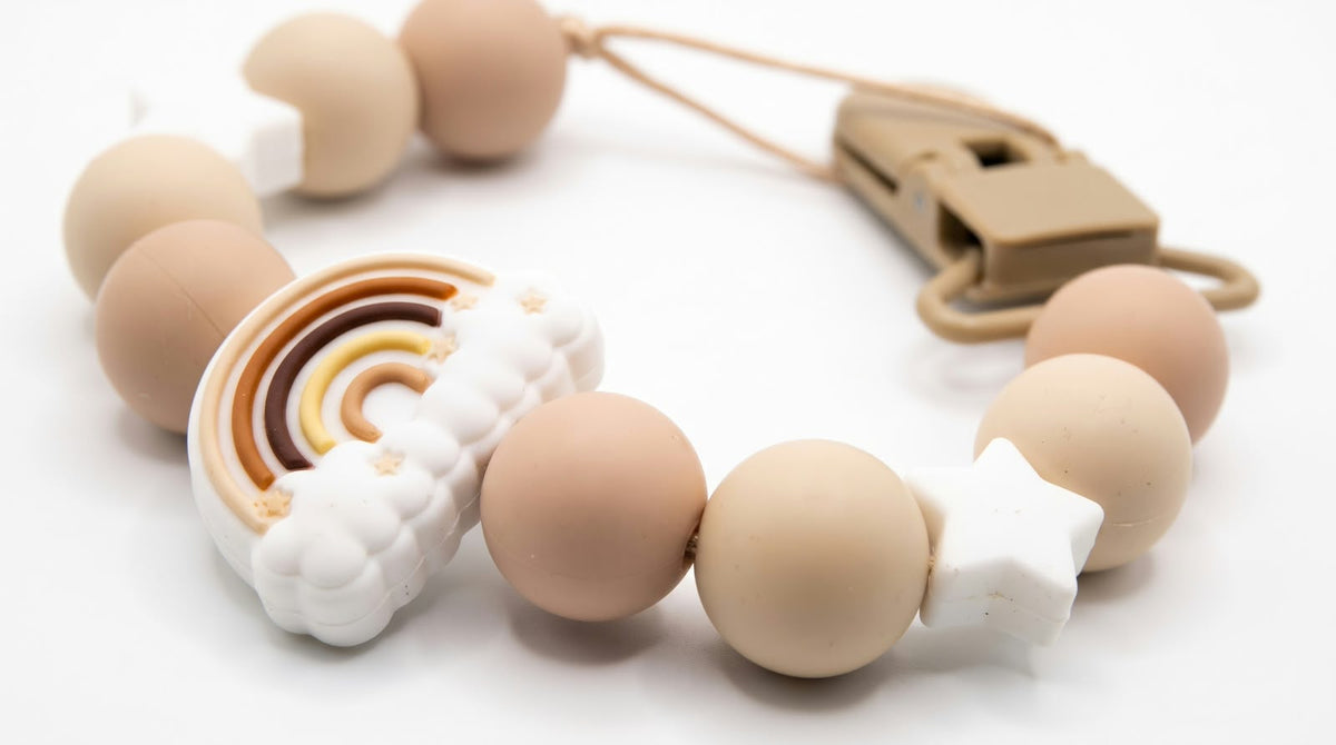 Portaciuccio arcobaleno beige in silicone con stelline bianche e clip