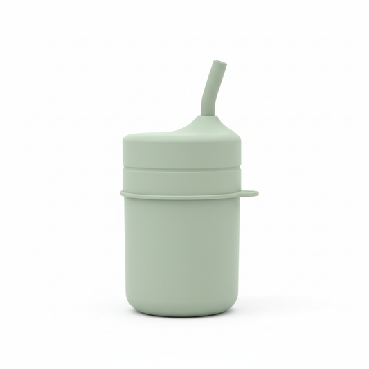 Bicchiere in silicone verde salvia con cannuccia su sfondo bianco
